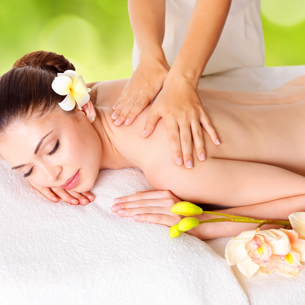 Woman having massage of body in the spa salon over green nature background